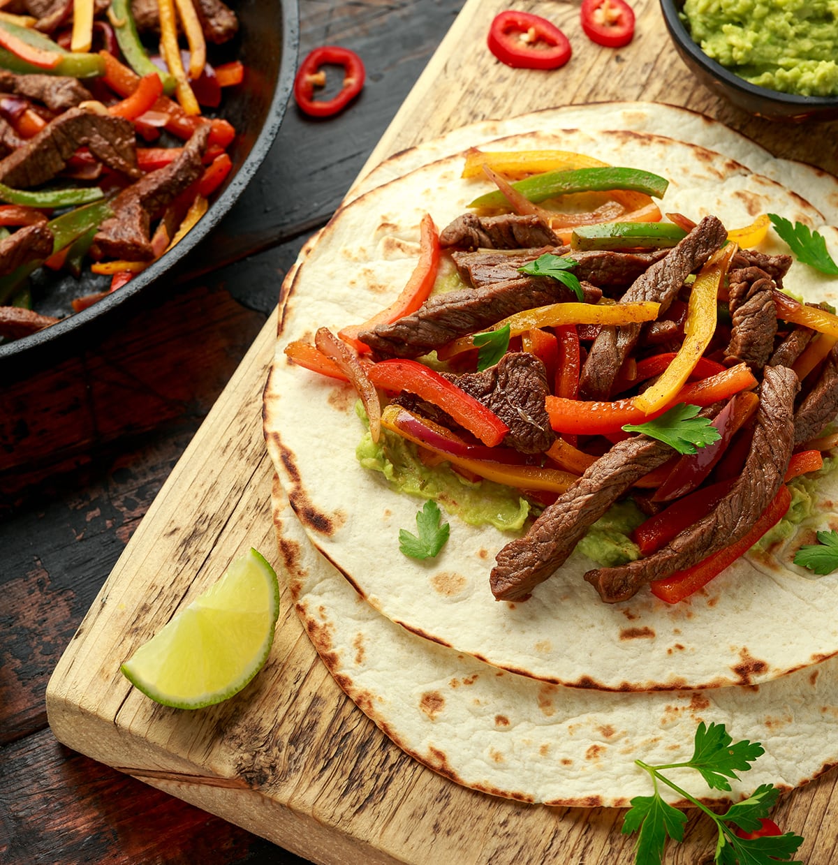 Beef steak fajitas with chopped peppers in a grilled tortilla.