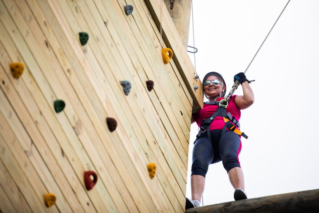 Smiling woman on top of a climbing course